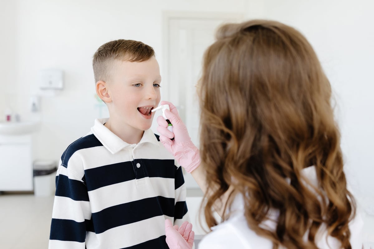 An allergist uses a spray for a patient to treat allergies. Allergen-specific immunotherapy.